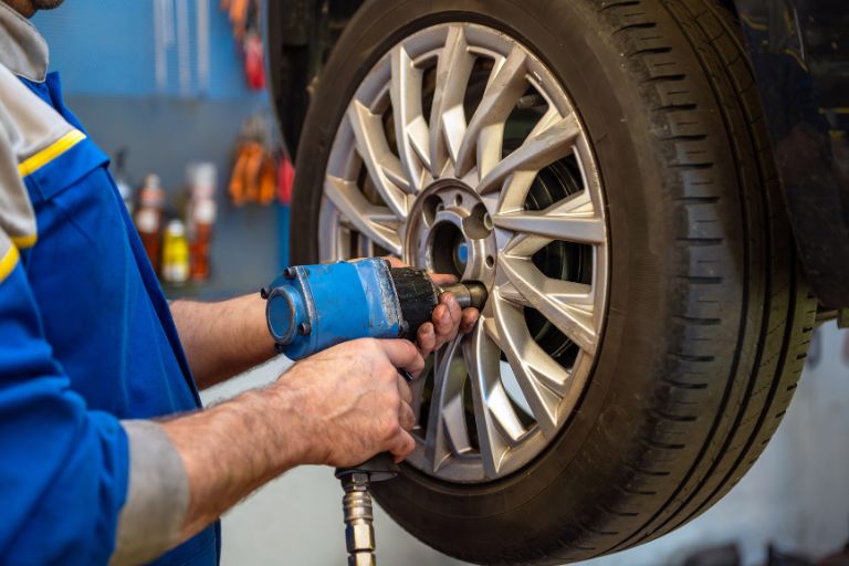 a man bolting a car wheel
