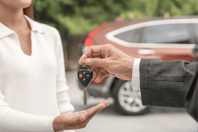 A woman collecting her car keys after completing her finance checks.