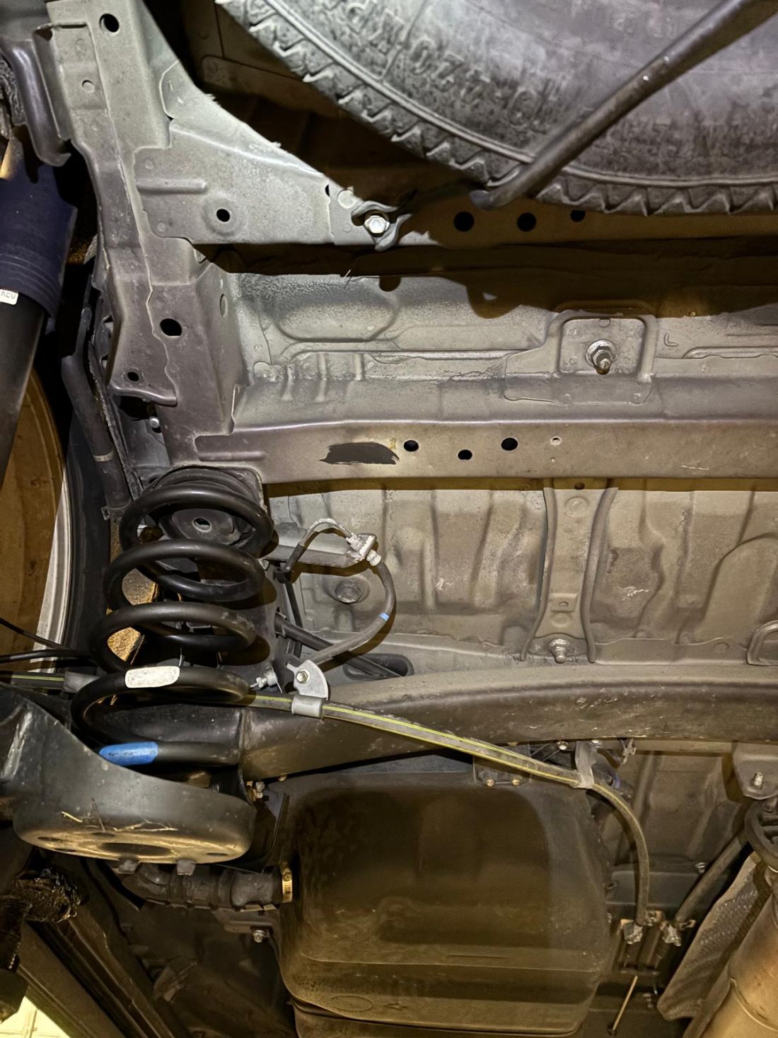 Pristine, rust-free underbody of a 14-year-old Japanese import vehicle, showing the excellent chassis condition typical of cars from non-salted Japanese roads.