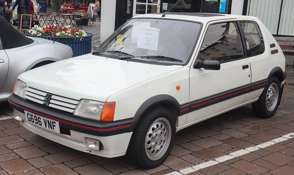1990 Peugeot 205 GTi 1.6 Front Taken at the 2018 Warwick Classic Car Show (Vauxford, CC BY-SA 4.0, via Wikimedia Commons)