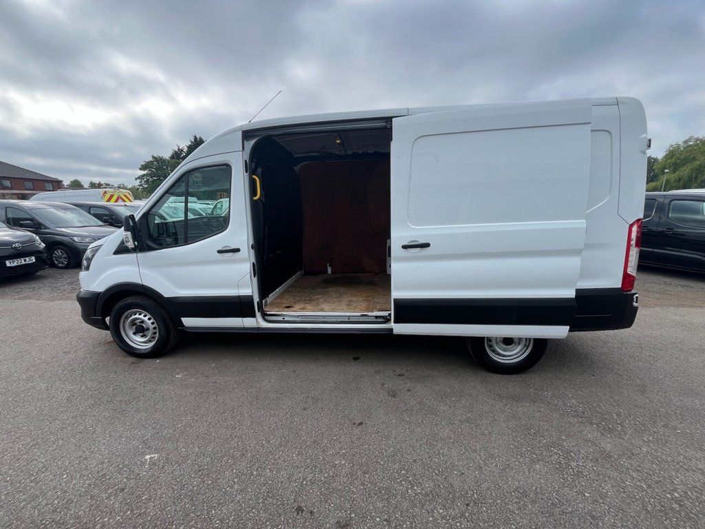 A White Ford Transit Custom with an Open Side Door