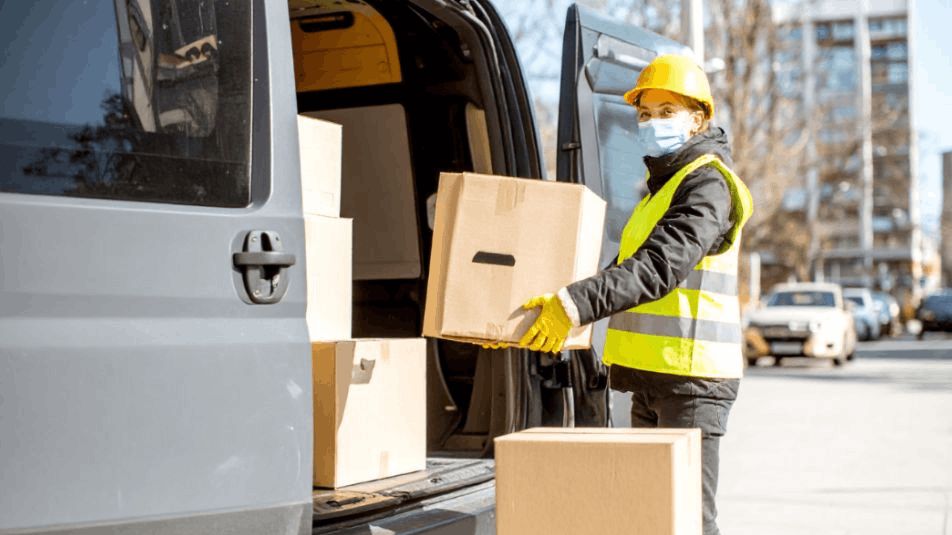 A Delivery Driver Next To An Open Van Filled With Boxes