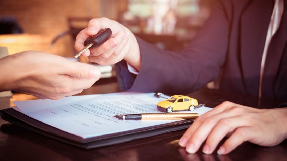 Car Keys Being Handed Over a Clipboard