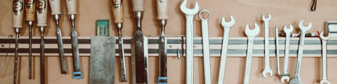 Tools hung on a metalic strip on the wall