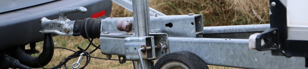 A grey metal towbar connecting a van to a caravan