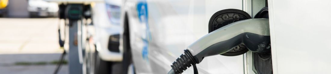 An electric vehicle connected to a charging station, indicating the process of recharging its battery.