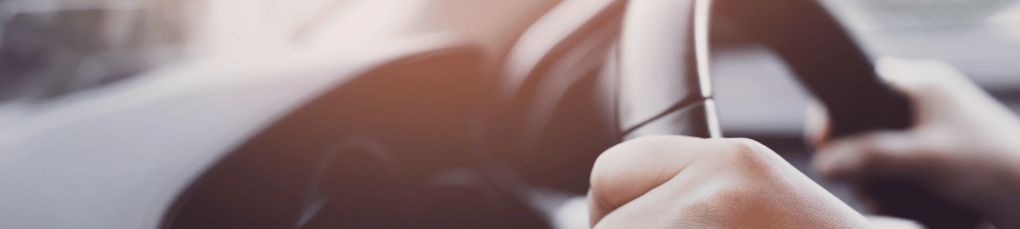 Two hands photographed on a steering wheel
