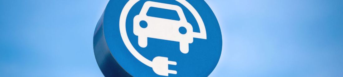A blue sign featuring a white electric car symbol.