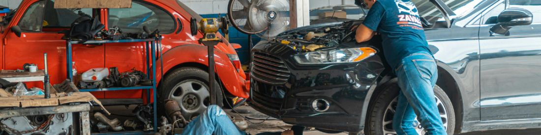 Two cars in a garage having work done to them