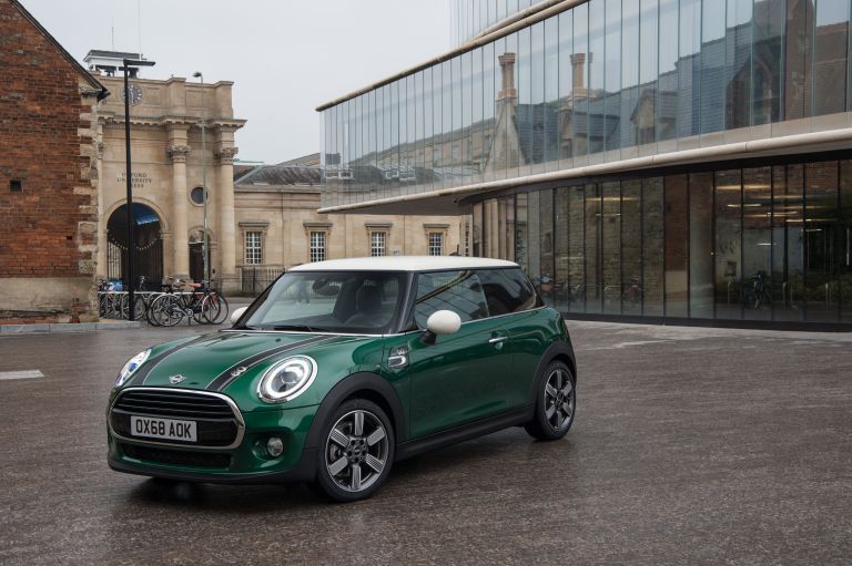 Green Mini Cooper with black stripes on the bonnet and a white roof.
