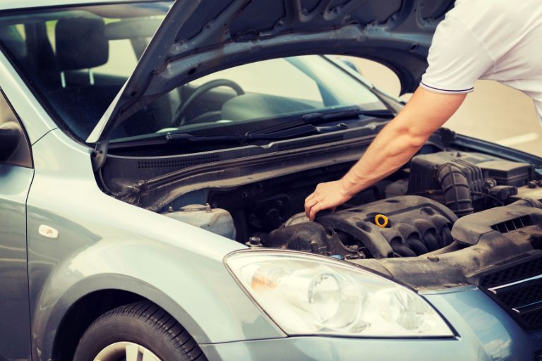 Vehicle servicing and maintenance check on used family car engine.