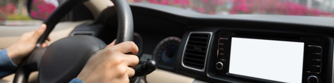 Hands gripping steering wheel while driving modern vehicle.