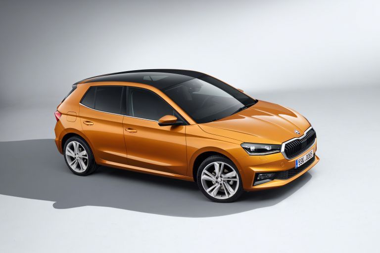 Orange Skoda Fabia in a white showroom.