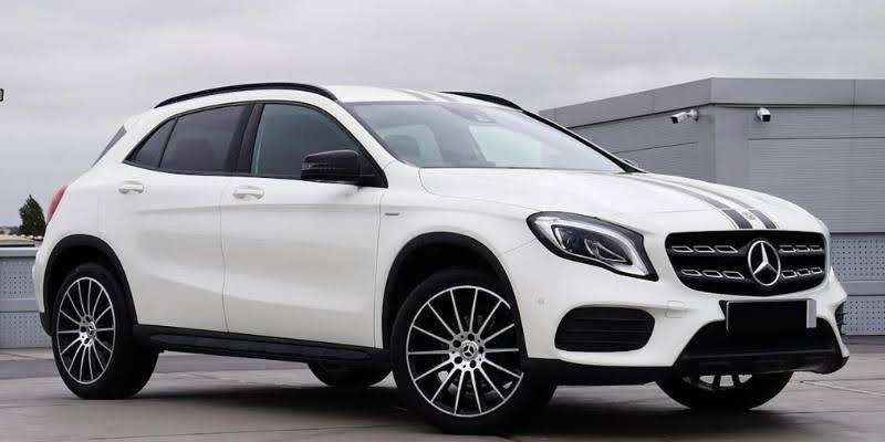 White Mercedes-Benz GLA SUV parked outdoors in front three quarter view.