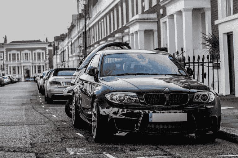 Black BMW 1 Series parked on a residential street.