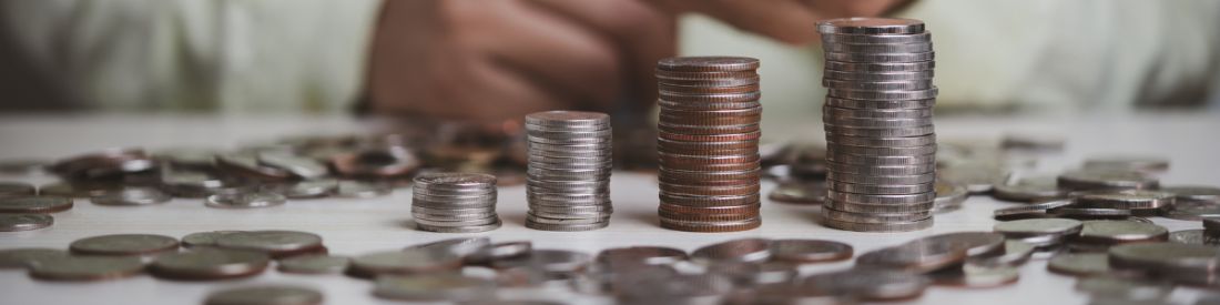 Copper and silver coins stacked up in piles increasing in size.