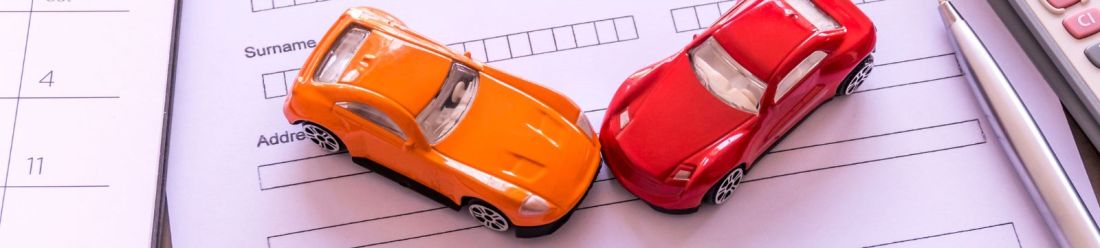 Car finance and insurance concept with model vehicles on application forms.