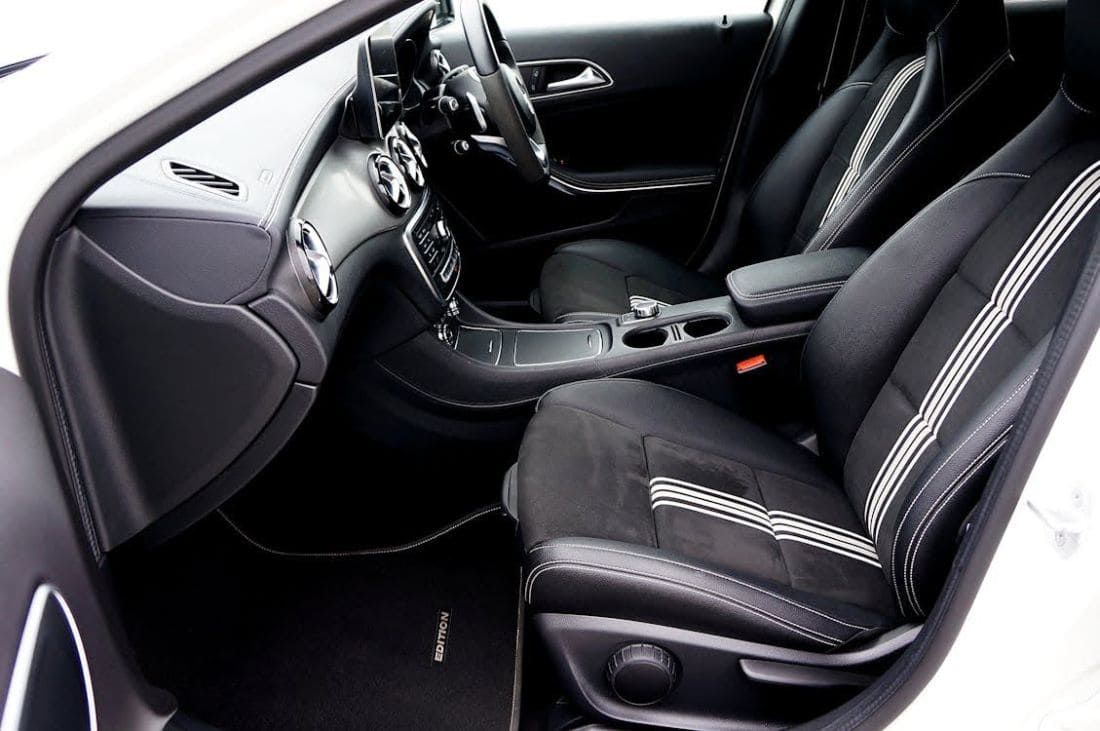 Premium Mercedes-Benz interior with black leather sports seats and centre console.