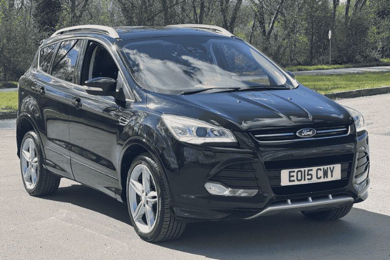 Black Ford Kuga car parked on a road in the sunshine.