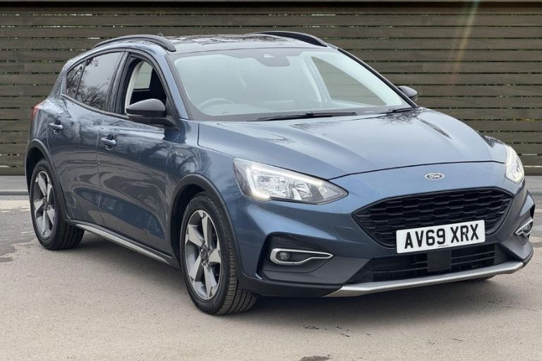 Blue Ford Focus hatchback front three-quarter view parked on dealership forecourt.