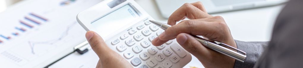 Person using calculator to work out car finance and monthly payments.